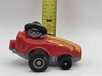 Side view of red McDonald's toy car with masked cat driver, ruler shows under 3 in length