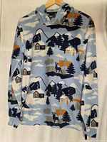 Front view of scenic print fleece hoodie on hanger