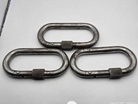 Three oval steel carabiners with threaded locking sleeves