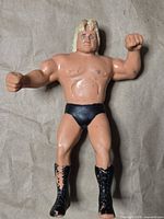 Front view of blonde wrestler figure showing pose, trunks, boots, paint wear