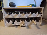 Front view of MDF rack showing scalloped slots, trowel and fork handles inserted
