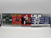 Front view of all four hockey cards in sleeves