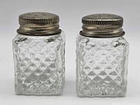 Front view of both glass shakers showing diamond quilted pattern and metal lids