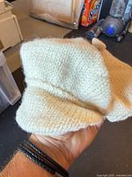 Side view of cream knit beret showing texture and brim