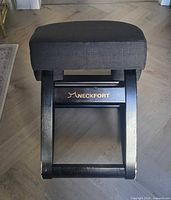 Front view of NeckFort chair showing seat, knee pads, frame