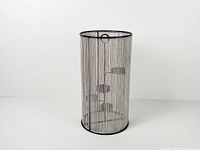 Full view of cylindrical candle holder with chain curtain
