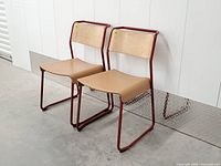 Both Canteen Utility chairs showing red steel frames, plywood backs, leather seats
