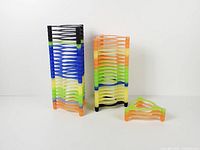 Two stacked columns of triangular neon plastic CD tower segments showing color variety and quantity