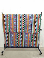Full view of folded cotton tablecloth on rack showing overall pattern and size