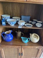 Full view of all ceramic items on cabinet shelves