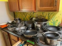 Countertop view showing entire assortment of pots, pans, bowls and bakeware