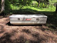 Front view of Dee Zee diamond plate truck box showing latches and brand badge