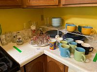Overview of stoneware plates, bowls, mugs, various glassware