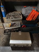 Stack of various toolboxes and cases with sockets visible