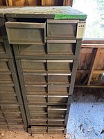 Front view of green metal storage cabinet with many drawers