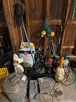 Overall view of lot showing soil bags, bocce set, traps, pail, sprayer, lantern, stakes, hose accessories