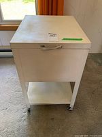 Front view of white metal mobile file cabinet on casters