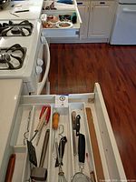 Drawer with assorted utensils – spatula, tongs, whisk, knives, peeler, strainer