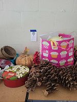Overall view showing pine-cone garland, pumpkin, tins, baskets and gift bag