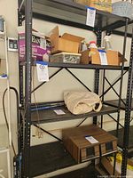 Full view of black metal shelving unit with four shelves