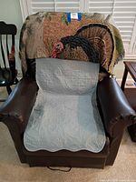 Front view of recliner with quilted protector and tapestry throw