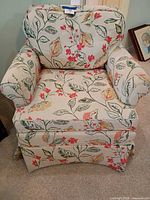 Front view showing floral upholstery, seat and back cushions, skirted base
