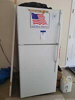 Front view of GE white refrigerator showing freezer on top and fridge below