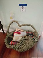 Full view of olive wicker basket showing heart-shaped handle and contents