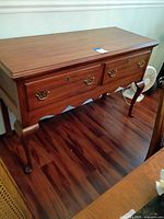 Front view of Henkel-Harris sideboard showing two drawers, brass hardware, scalloped apron, cabriole legs