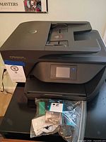 Full view of HP OfficeJet Pro 6968 printer with ink cartridges in plastic bag