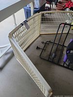 Three connected ivory plastic gate panels forming an L-shape on garage floor