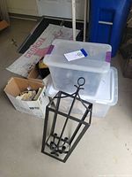 Chandelier resting beside storage totes and boxes