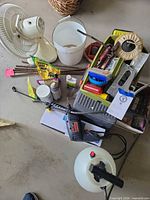 Overview of lot showing Skil drill, pump sprayer, green tote with tools, desk fan, rebar pieces