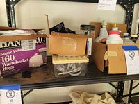 Shelf with Handi Bag box, beige storage box with cords and cardboard boxes