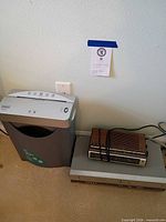 Shredder, VCR, clock radio grouped together on floor