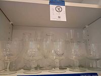 Shelf showing assorted clear glass stemware pieces