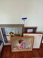 Group of four framed artworks leaning together