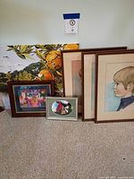 Group shot of five artworks leaning against wall