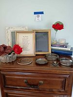 Full lot on dresser showing frames, glass dishes, books, candle, flower