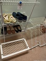 Wide view of shoe rack holding five pairs of shoes