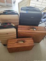 Group shot of three polycarbonate suitcases and two leather suitcases