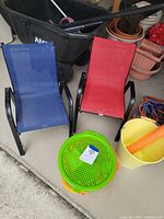 Front view of both chairs showing blue and red mesh seats, black metal frames