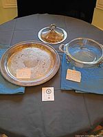 Full view of platter, bowl stand with glass insert, and lid displayed on table