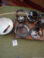 Group view of all six silver-plated pieces on rug and tray