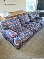 Front angled view of plaid sofa showing cushions and upholstery