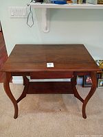 Front angled view of console table showing overall form, drawer and shelf