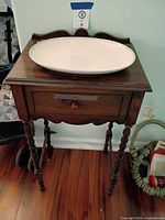 Front view of wood side table with white oval platter on top