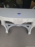 Front view of white distressed Rococo console table