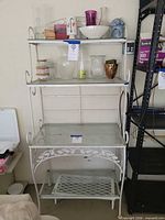Full view of white metal etagere with glass shelves