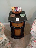 full view of end table between chairs with basket and coasters on top